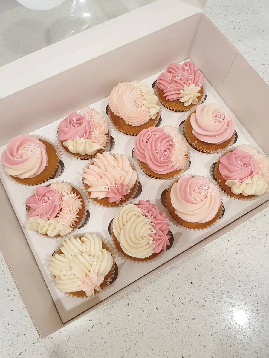 A box of twelve pink and white Miss Sprinkles cupcakes